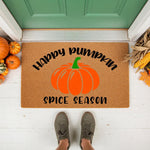 Happy Pumpkin Spice Season coir doormat for fall porch decor, featuring a large orange pumpkin graphic on natural fiber, perfect for autumn entryway welcome mats and seasonal home decorations in front of a green front door.