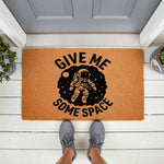 Astronaut Give Me Some Space doormat featuring a funny outer space design on natural coir fiber, perfect as a quirky front porch welcome mat for science lovers or anyone who enjoys humorous home decor and unique entryway floor