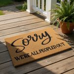 Funny doormat with Sorry We're All Peopled Out text, a natural coir fiber welcome mat for front porch decor, this humorous outdoor floor rug features bold black lettering on a durable brown textured surface for a stylish home
