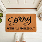 Funny Sorry We Are All Peopled Out doormat for front porch entry, featuring a natural coir fiber welcome mat with bold black text, perfect for a humorous home decor entrance or a quirky housewarming gift for introverts and