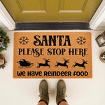 Christmas doormat featuring Santa, his sleigh, and reindeer silhouettes with the text Santa Please Stop Here We Have Reindeer Food, a festive holiday welcome mat for your front porch decor during the winter season.