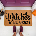 Funny Halloween doormat with Witches Be Crazy text, featuring a witch hat and bat graphic on natural coir fiber.