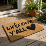 Welcome Y'all coir doormat with a black heart design, featuring a natural fiber welcome mat for front porch entryways that adds a rustic farmhouse touch to your home decor and outdoor entryway floor covering for guests.
