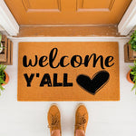 Welcome Y'all doormat with a heart design, a natural coir fiber welcome mat for front porch decor, featuring black text on a rustic tan background, perfect for farmhouse entryway floor mats and outdoor home entrance styling.