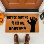 Spooky Halloween doormat featuring a zombie hand graphic and text on a natural coir welcome mat, perfect for fall porch decor, horror movie fans, and front door entryways during the autumn season for a fun and scary home entrance