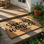 Sweater Weather coir doormat featuring black script text and a leaf branch design on a natural fiber welcome mat, perfect for fall porch decor, autumn home entryways, and seasonal front door floor mats for your house or apartment.