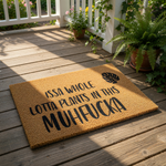 Funny plant lover doormat with bold text reading Issa Whole Lotta Plants In This Muhfucka, featuring a tropical leaf design on a natural coir fiber welcome mat for indoor or outdoor home entryway decor and housewarming floor rug.