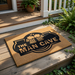 The Man Cave coir doormat features a black printed design of two clinking beer mugs, making this durable natural fiber welcome mat a fun decor choice for a basement, garage, home bar, or any room dedicated to relaxation and beer