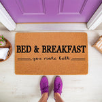 Funny Bed and Breakfast doormat with humorous text you make both, featuring a natural coir fiber welcome mat placed on a porch in front of a purple door, perfect for a housewarming gift or a stylish front door entrance decor