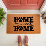 Dog lover home sweet home doormat with paw print design, a natural coir fiber welcome mat for front porch decor, featuring bold black text and a cute pet theme for dog owners placed on a white entryway floor with red door