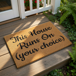Funny welcome doormat for front porch featuring the text This House Runs On Your choice in black script on natural coir fiber, a durable outdoor floor mat for home entryways that adds a humorous touch to your front door decor.