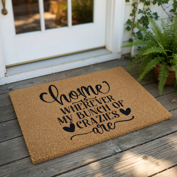 Funny family quote doormat featuring the text Home is wherever my bunch of crazies are in black script and serif fonts on a natural coir fiber welcome mat, perfect for a front porch entry or a housewarming gift for a busy family
