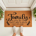 Family welcome doormat with a funny quote, featuring natural coir fiber material and black script text that reads A Little Bit Of Crazy And A Whole Lot Of Love, perfect for a front porch entryway or housewarming decor for any