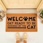 Funny cat welcome doormat for front porch, featuring a humorous quote about being ignored by the cat with a paw print design on natural coir fiber, perfect for pet lovers and home entryway decor in a stylish outdoor setting.