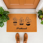 Pothead houseplant doormat featuring three potted plant illustrations on a natural coir welcome mat, perfect for a plant lover front porch decor or a funny housewarming entry rug for indoor or outdoor home entrance use.