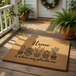 Cactus plant welcome doormat with natural coir fiber texture, featuring a black printed design of five potted succulents and the text Home is where my plants are, perfect for a front porch entry rug or a housewarming gift for
