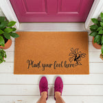 Plant your feet here doormat featuring a natural coir fiber welcome mat with black script text and a leaf design, placed on a white porch in front of a magenta door for a stylish home entrance decor look that greets guests warmly.