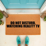 Funny Do Not Disturb Watching Reality TV doormat for front porch entryways, featuring bold black text on a natural coir fiber welcome mat, perfect for home decor lovers who enjoy television humor and unique outdoor floor mats.
