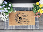 Skull floral doormat with funny quote about murder shows and comfy clothes, featuring a natural coir welcome mat on a porch layered over a gray plaid rug, perfect for a dark humor home decor entryway or a unique front door