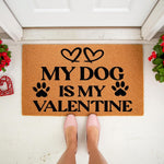 My Dog Is My Valentine doormat featuring black text, hearts, and paw prints on a natural coir fiber welcome mat, placed on a front porch for a festive holiday home decor look that celebrates pet love for dog owners and animal