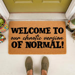 Funny welcome doormat with the text Welcome to our chaotic version of normal, a natural coir fiber outdoor rug for front porch decor that makes a humorous housewarming gift for friends, family, or new homeowners to display.