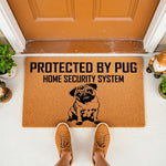 Pug dog welcome doormat featuring a funny protected by pug home security system design on natural coir fiber, perfect for a front porch entrance, dog lover home decor, or a unique housewarming gift for pet owners.