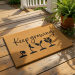 Keep Growing coir doormat featuring a black plant growth cycle graphic on a natural fiber welcome mat, perfect for a garden lover home entrance or front porch decor with a durable outdoor rug design for housewarming.