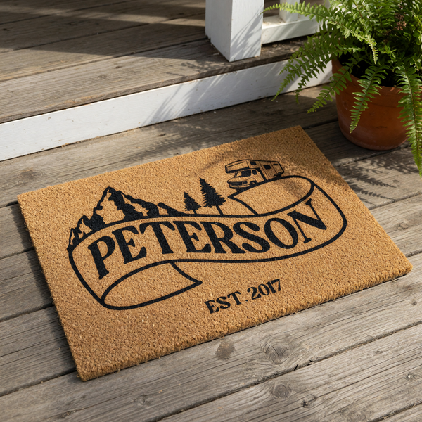Personalized camping doormat featuring a mountain and camper van design on natural coir fiber, perfect as a custom family name welcome mat for outdoor enthusiasts and RV owners looking for durable front porch decor for their home.
