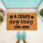 Crazy Dog Lady doormat for front porch entry, featuring bold black text and paw prints on a natural coir fiber welcome mat, perfect for pet lovers and dog owners looking for funny home decor to place outside their front door.