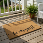 Be Our Guest coir doormat featuring natural fiber construction and elegant black script lettering, this durable outdoor welcome mat adds a stylish touch to your front porch entryway decor for guests and visitors.