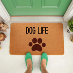 Dog Life coir doormat featuring a large brown paw print design, placed on a front porch entryway as a stylish welcome mat for pet lovers who want a durable outdoor rug for their home entrance and dog decor for their front door.