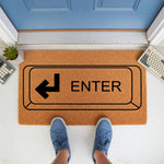 Enter key doormat featuring a computer keyboard design on natural coir fiber, perfect for a tech lover home entrance or office decor, shown on a porch with blue shoes standing on the welcome mat in front of a blue front door.