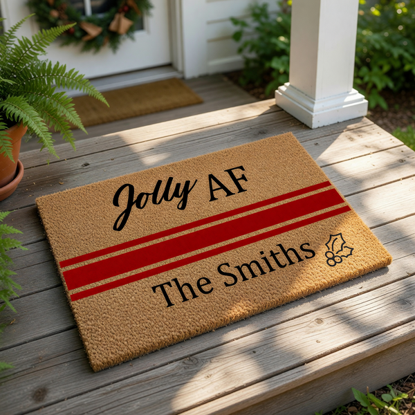 Personalized Christmas doormat featuring the funny phrase Jolly AF and a custom family name, this natural coir welcome mat has a festive red stripe and holly design for a humorous holiday front porch decor look for your home