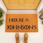 Personalized family name doormat featuring custom text on a natural coir welcome mat, perfect for a front porch entry.