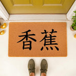 Natural coir fiber welcome doormat featuring bold black Chinese characters for banana, placed on a front porch entryway floor mat, creating a stylish and functional home decor accent for your front door entrance area.