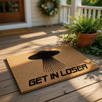 UFO alien doormat featuring a black flying saucer graphic and the text Get In Loser, this funny coir welcome mat is a quirky outdoor floor rug for sci-fi fans who want a humorous entrance decor piece for their home or apartment