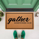 Funny Gather Somewhere Else doormat featuring bold black text on a natural coir fiber welcome mat, perfect for a front porch entry, housewarming decor, or a sarcastic home entrance rug that keeps guests away from your front door.