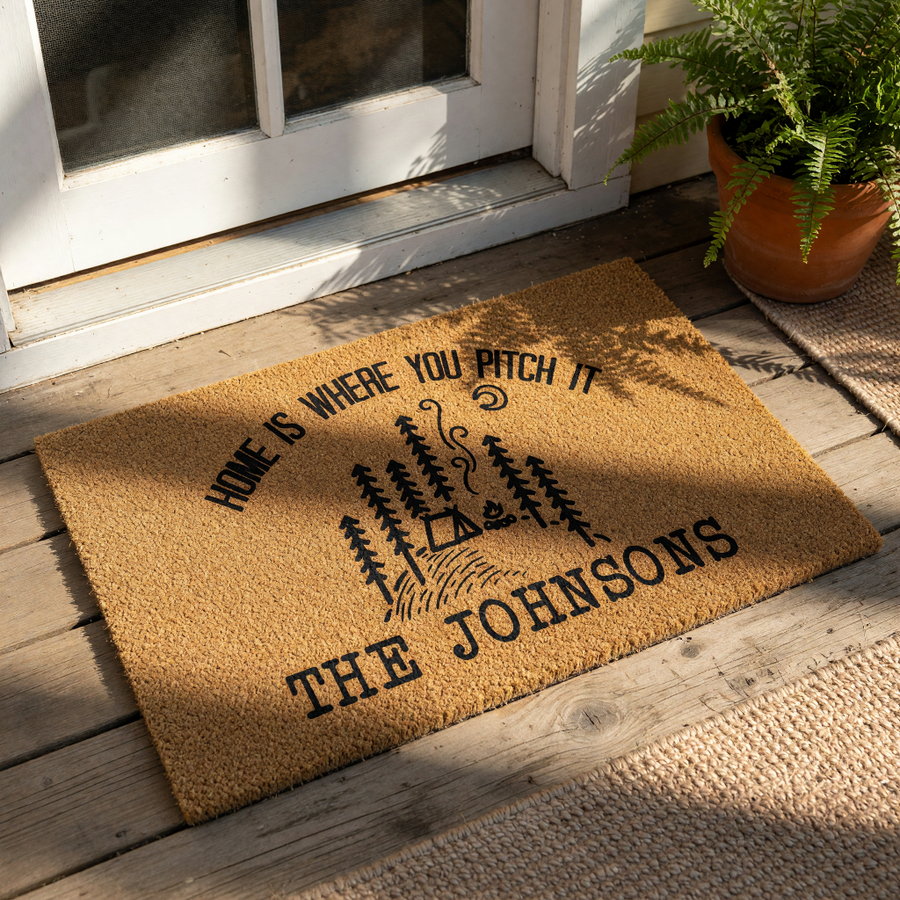 Personalized camping doormat with a forest and tent design, featuring the text Home Is Where You Pitch It and a custom family name.