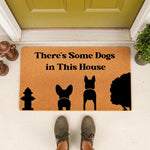 Funny dog doormat with text There is Some Dogs in This House, featuring black silhouettes of a fire hydrant and dog breeds on a natural coir fiber welcome mat, perfect for a pet lover porch decor or a unique housewarming entrance