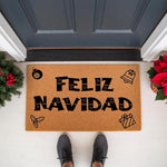 Feliz Navidad Christmas doormat featuring festive holiday icons like a bell and gift on natural coir fiber, perfect for a seasonal front porch welcome mat decor that adds a cheerful touch to your home entrance during the winter