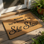 Funny Welcome You've Arrived At The Shit Show doormat featuring bold black text on a natural brown coir fiber mat, perfect for a humorous front porch entry, housewarming decor, or a sarcastic home entrance floor rug for your