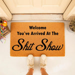 Funny welcome doormat with the text You've Arrived At The Shit Show, a natural coir fiber outdoor rug for your front porch entry that makes a humorous housewarming gift for friends who love sarcastic home decor and funny door