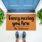 Personalized family name doormat featuring the phrase Fancy meeting you here on a natural coir fiber welcome mat, perfect for a front porch entryway decor update with a stylish script font and durable outdoor floor mat