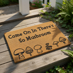 Mushroom welcome doormat with funny pun text Come On In There's So Mushroom, featuring black line art illustrations of various fungi on a natural coir fiber mat for a cute outdoor entryway or front porch decor floor rug.