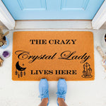 Crystal Lady welcome doormat with moon and gemstone design, a funny coir entry rug for home decor, featuring black text on a natural fiber mat placed on a porch, perfect for a boho house entrance or a unique housewarming gift