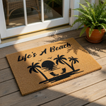 Life's A Beach tropical doormat featuring a black sunset, palm trees, and lounge chairs on a natural coir fiber welcome mat, perfect for coastal home decor, summer porch entryways, and beach house outdoor floor mat entryway rugs.