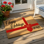 Personalized Happy Holidays doormat featuring a festive red gift ribbon design on natural coir fiber, making a custom family name welcome mat for your front porch decor during the winter season and holiday home entry.