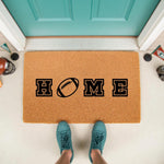 Football home doormat featuring a sports-themed design with a football replacing the letter O, perfect for a front porch entrance mat, outdoor welcome rug, or housewarming decor for sports fans who love game day football season.