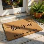 Personalized family doormat featuring the phrase this is us in elegant black script on a natural coir fiber welcome mat, providing a custom entryway floor rug for home decor that highlights your family names in a modern style.