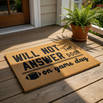 Football game day doormat with natural coir texture and black text reading Will Not Answer The Door On Game Day, a funny sports welcome mat for front porch entryways that is perfect for football fans and home decor enthusiasts.